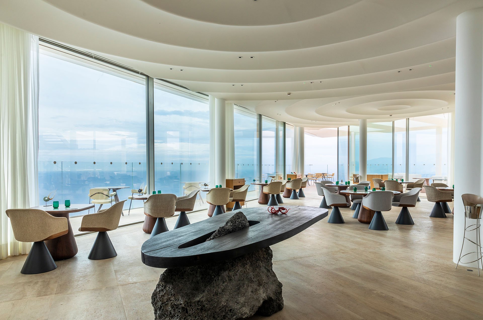Seaview Ceto restaurant with a rock in the centre and tables with chairs around it.