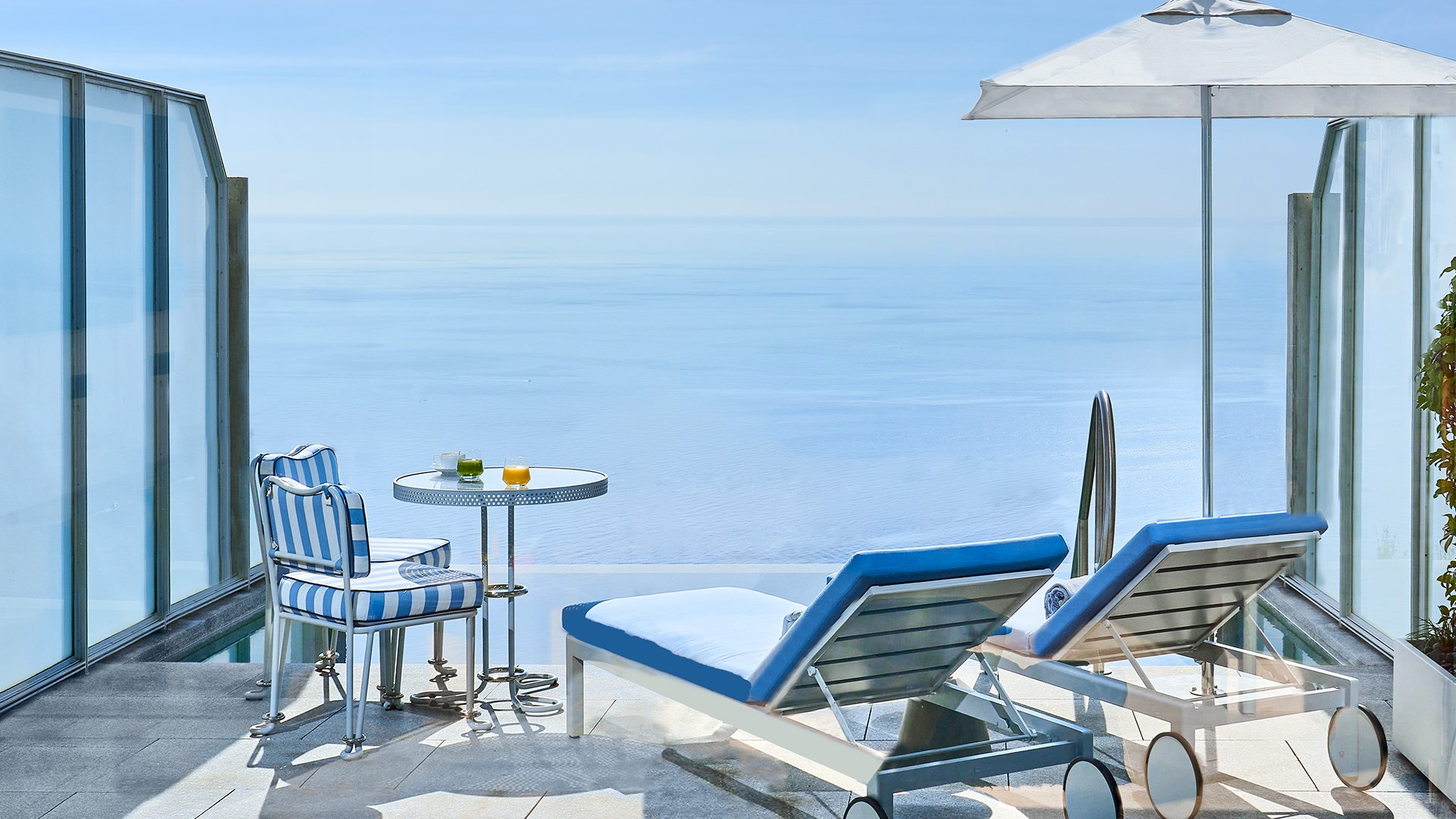 Une terrasse avec deux transats, une table et deux chaises, et une piscine privée dans la Suite Duplex Pool au Maybourne Riviera.