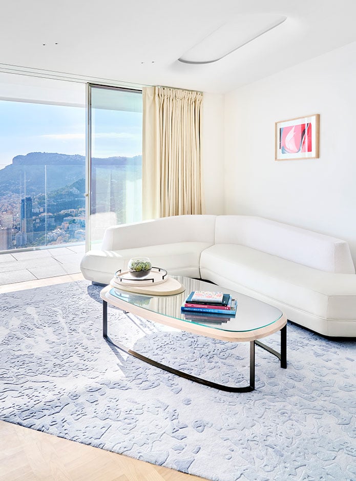 A large white sofa next to a table in a room with sea views at the Riviera Suite.