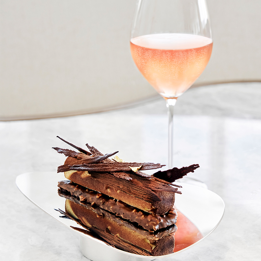 Chocolate cake on a plate with a glass of Champagne Rosé on the side. Chocolate cake on a plate with a glass of Champagne Rosé on the side.