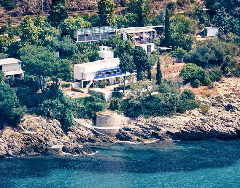 A house on the hilly coast next to the sea.