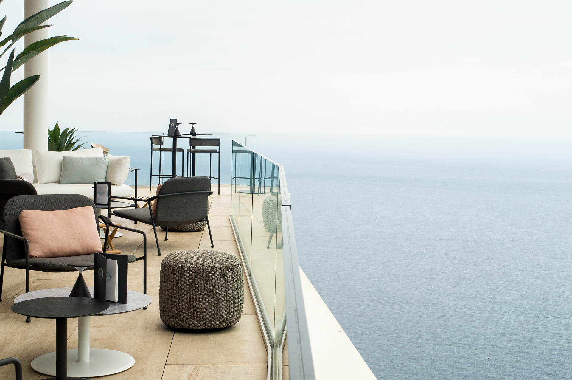 Bar Ceto at The Maybourne Riviera - terrace with lounge chairs, high chairs and sofa and view onto the sea.