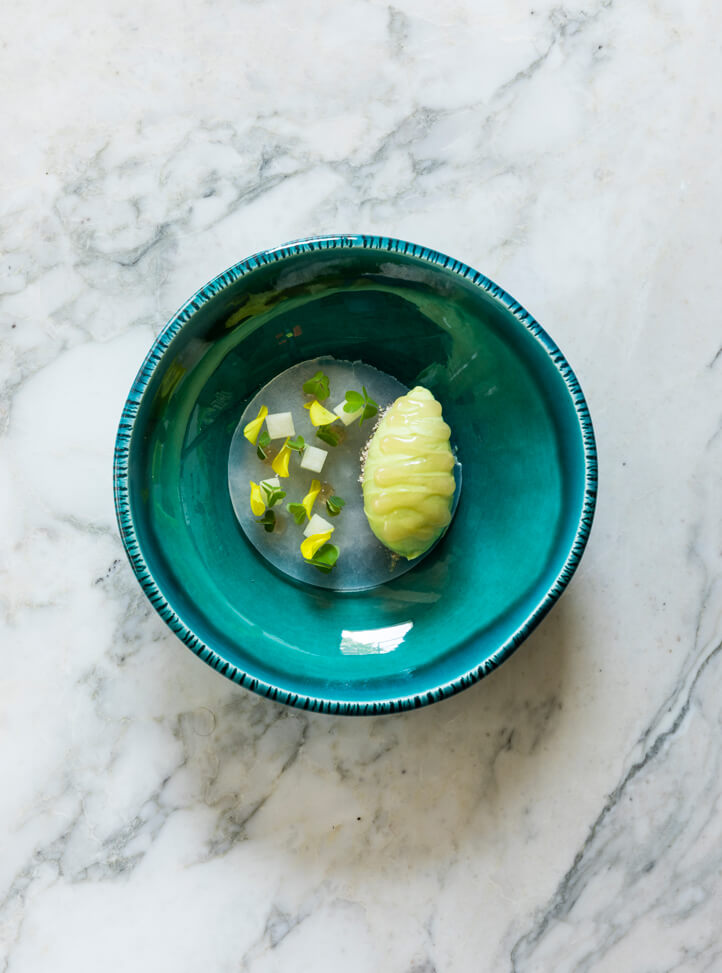 A deep turquoise blue plate with vegetables.