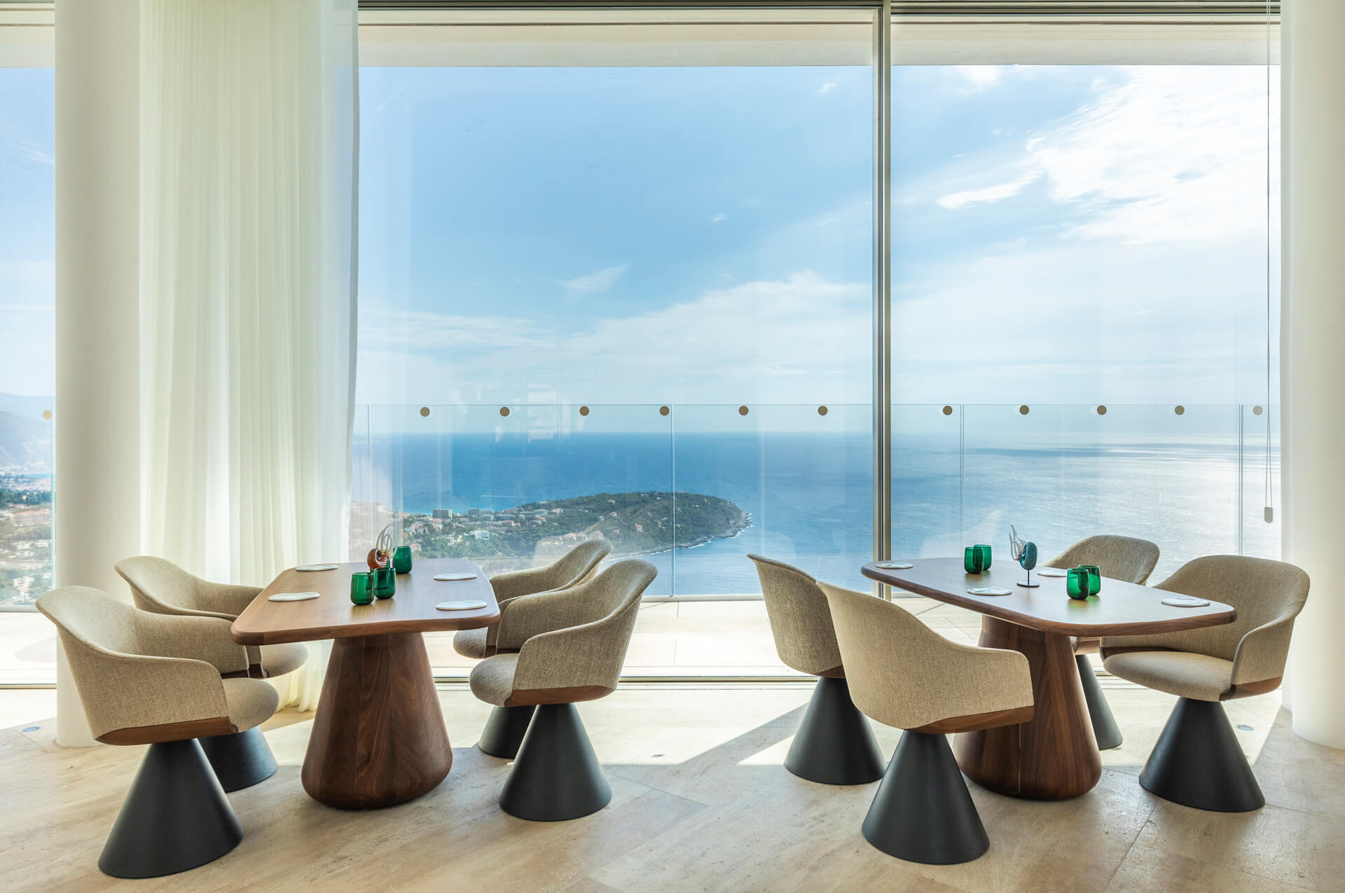 Two wooden tables with modern chairs next to a huge terrace with sea views at Ceto restaurant.