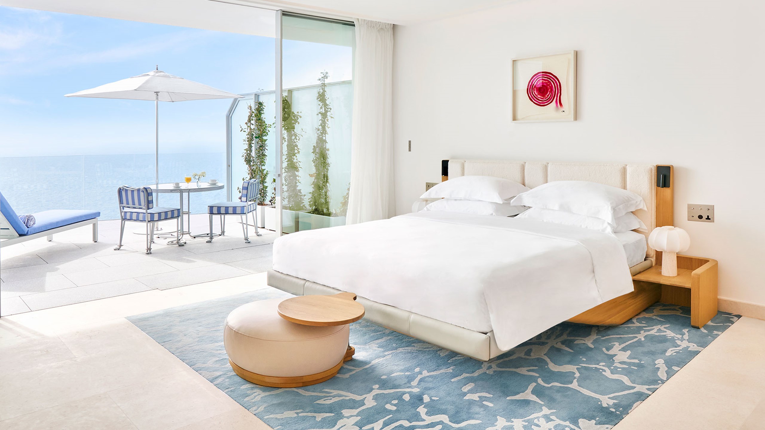 The Grand Sea View Studio is a modern white room featuring chic wooden themes and a uninterrupted view of the sea