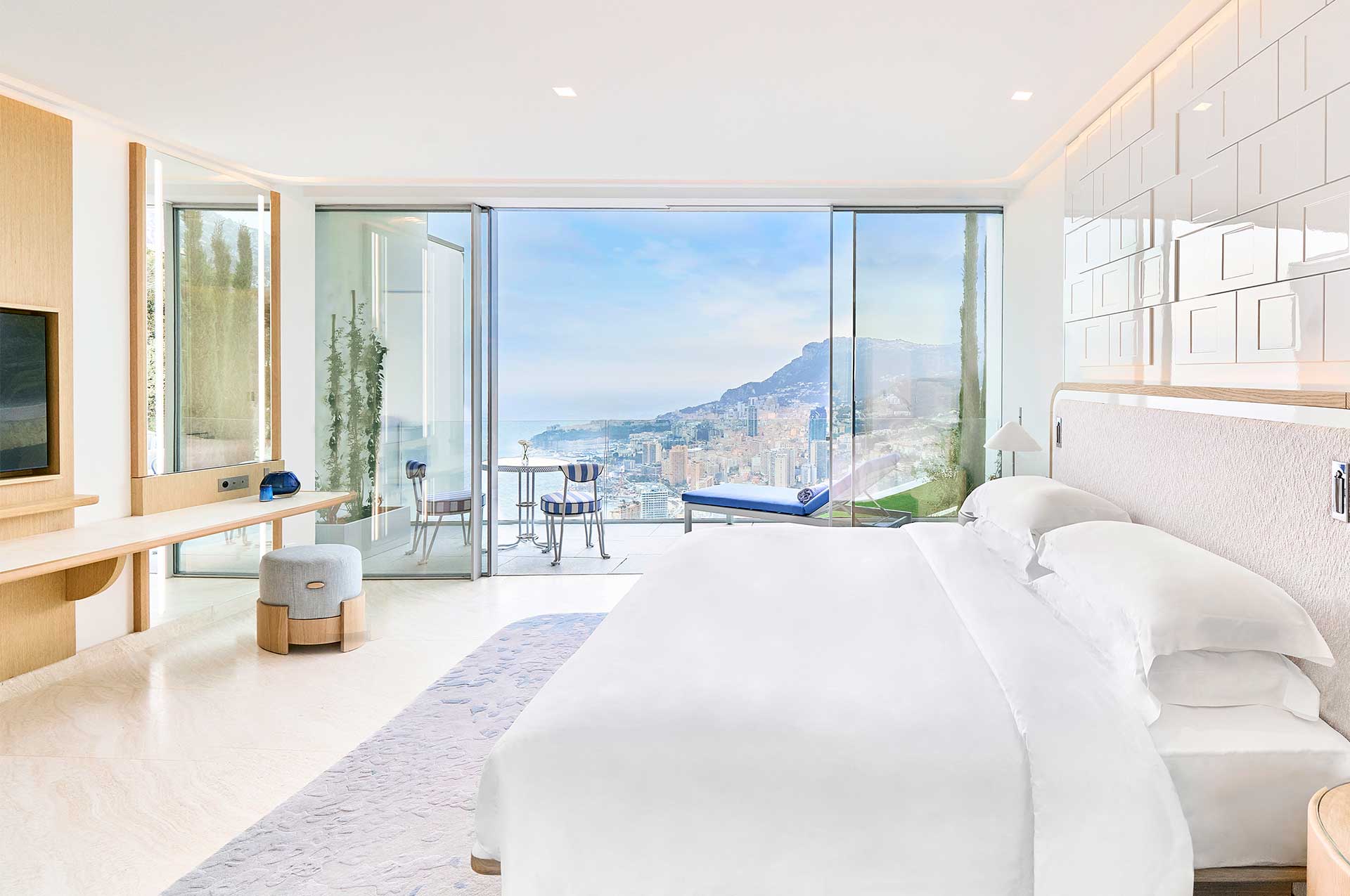 The crispy white decor of the Sea View Suite features a beautiful modern bed in the centre overlooking panoramic views of Monaco