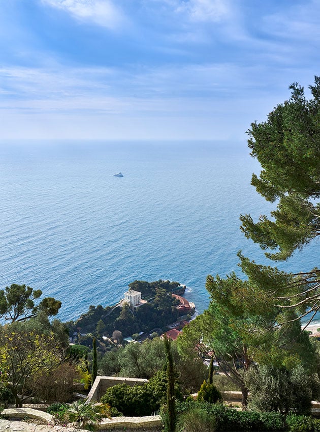 The sea, the sky and trees seen from the coast.