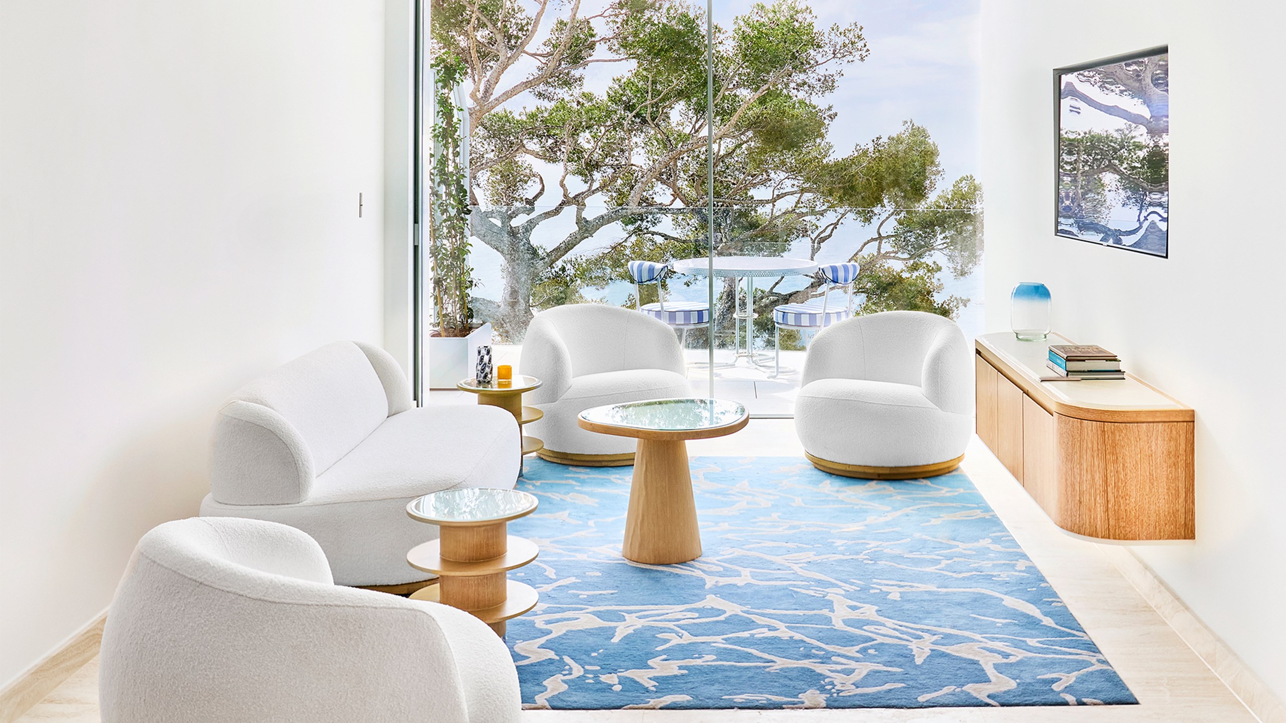 Suite Corniche - Salon avec canapés et table basse, et terrasse avec table et chaises.
