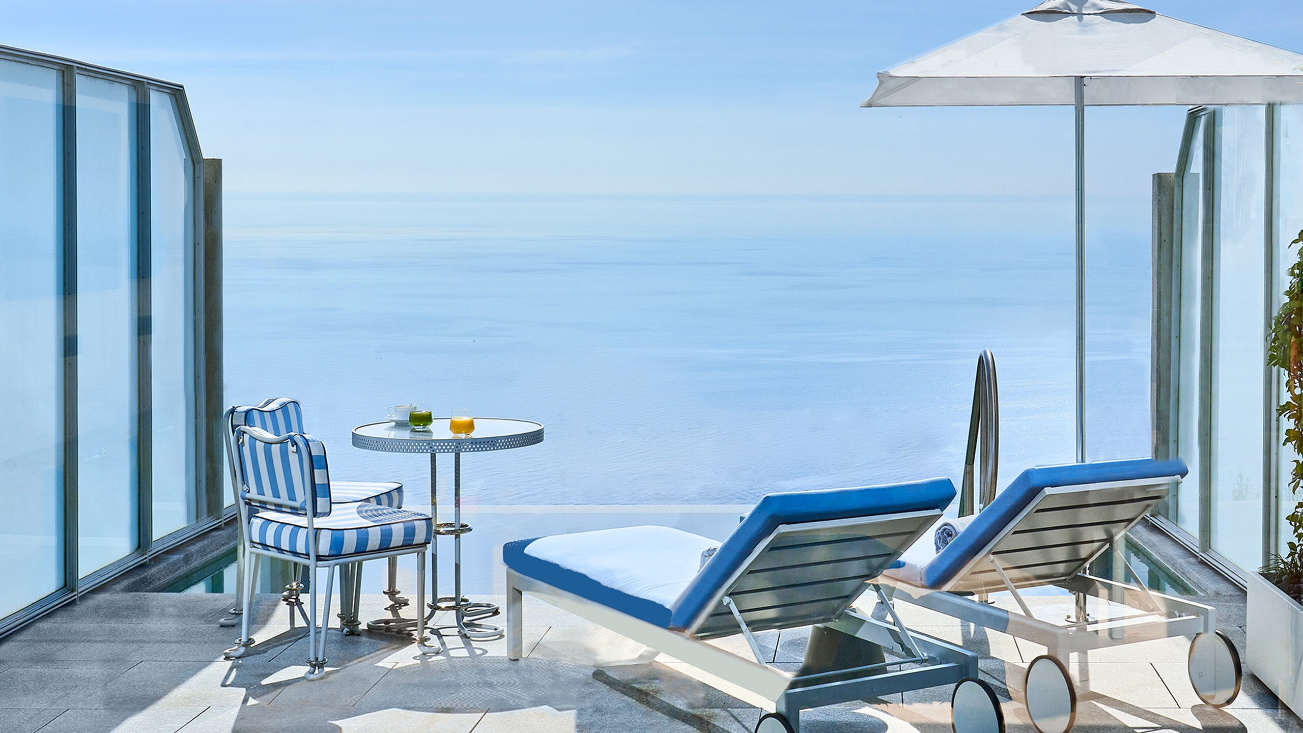 Une terrasse avec deux transats, une table et deux chaises, et une piscine privée dans la Suite Duplex Pool au Maybourne Riviera.