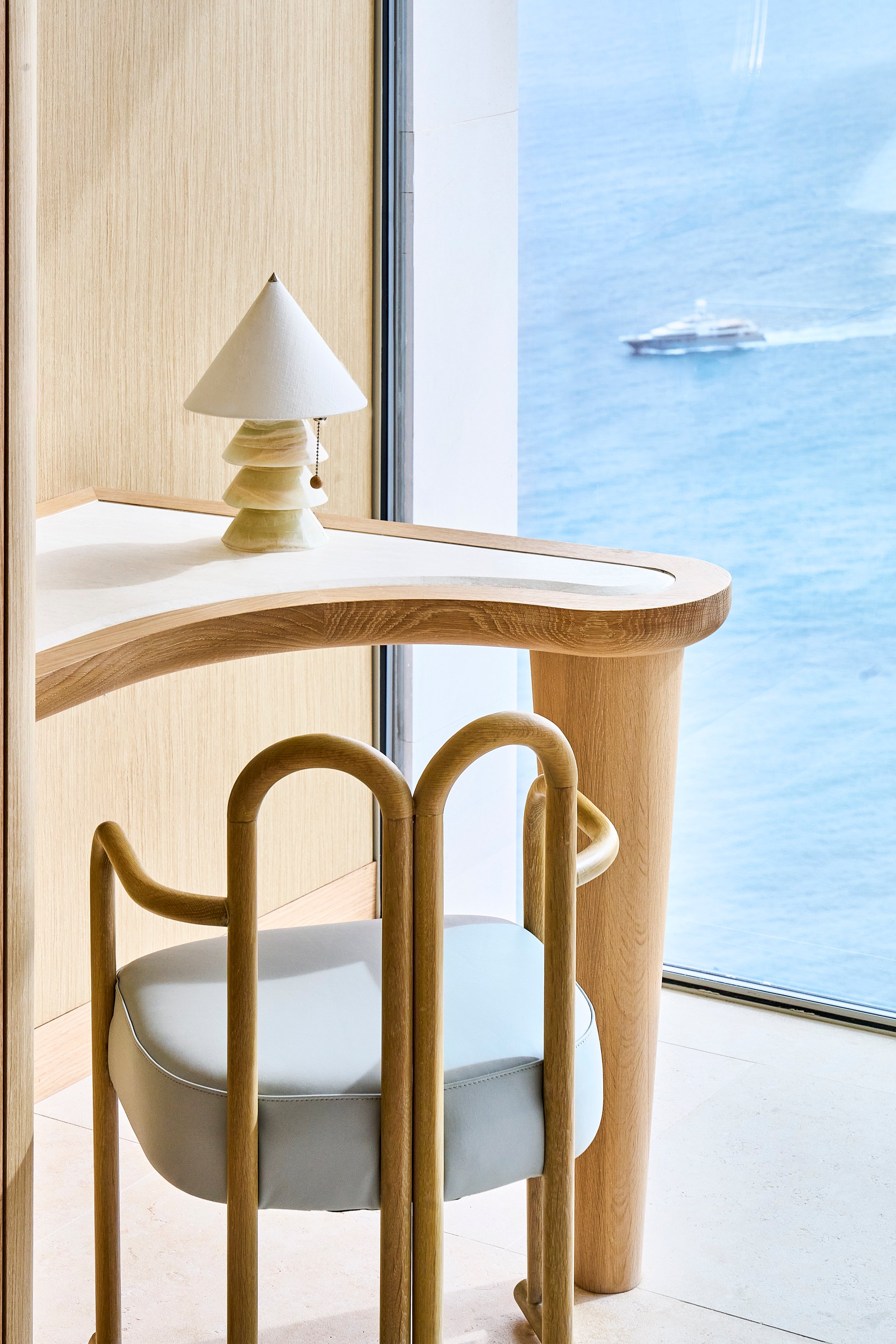 The Maybourne Riviera - desk with chair in front of it and view onto the sea through the window.