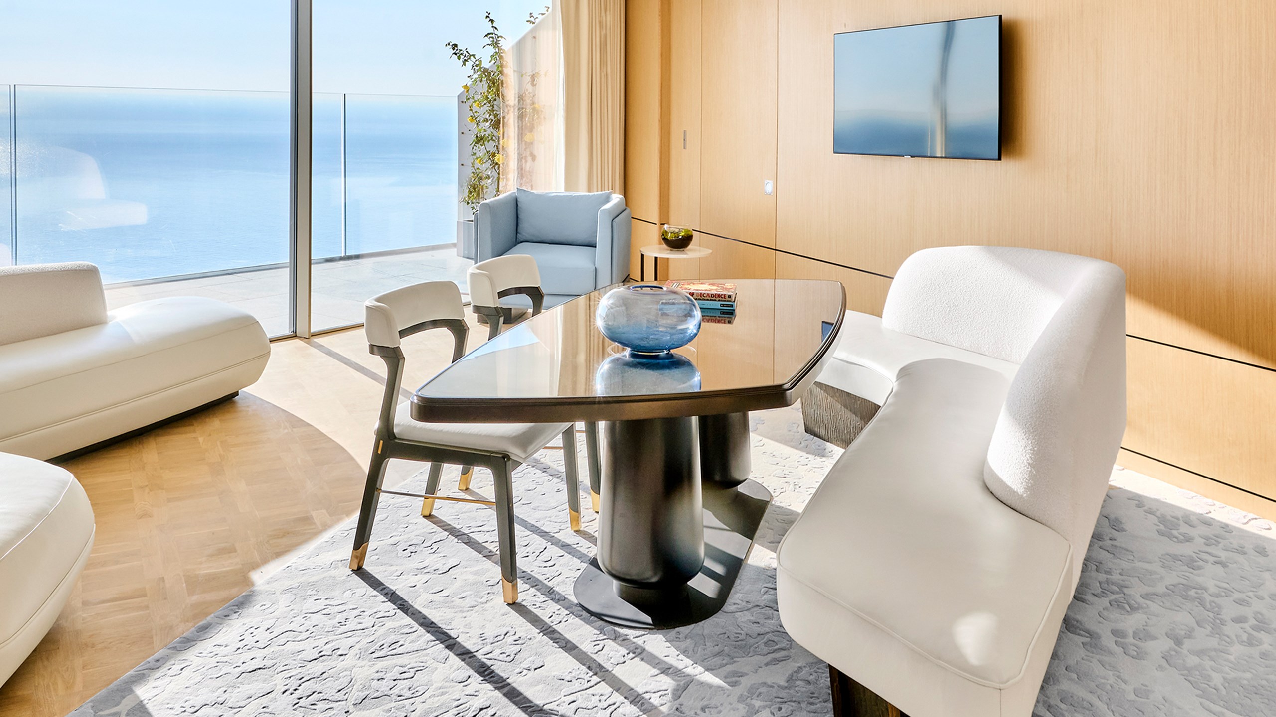 Riviera Suite - lounge with sofa, table and armchair and view on the sea.
