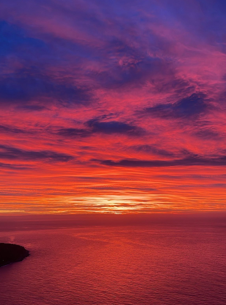 Coucher de soleil sur la mer colorant le ciel de rose et de rouge.