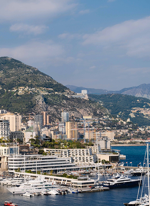 Vue du port de Monaco avec ses yacht et le Maybourne Riviera dans les hauteurs.