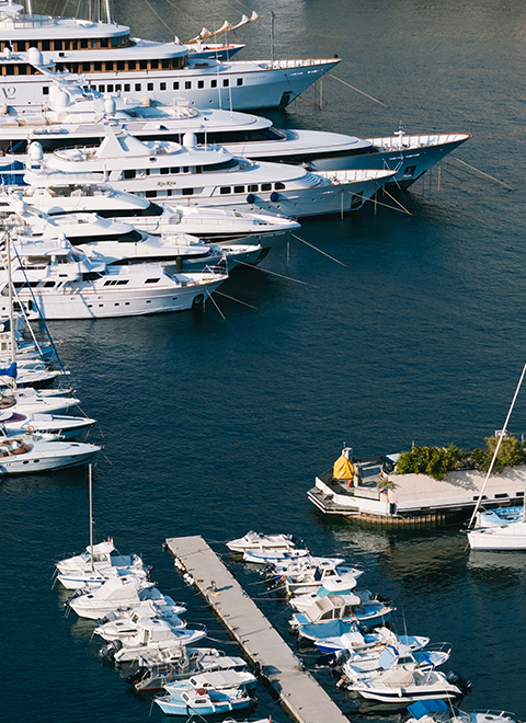Vue de haut sur une partie du port de Monaco avec des bateaux, yachts et superyachts amarrés.