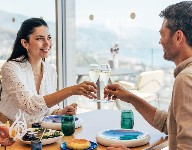 Man and woman smiling with glass of champagne in hand.