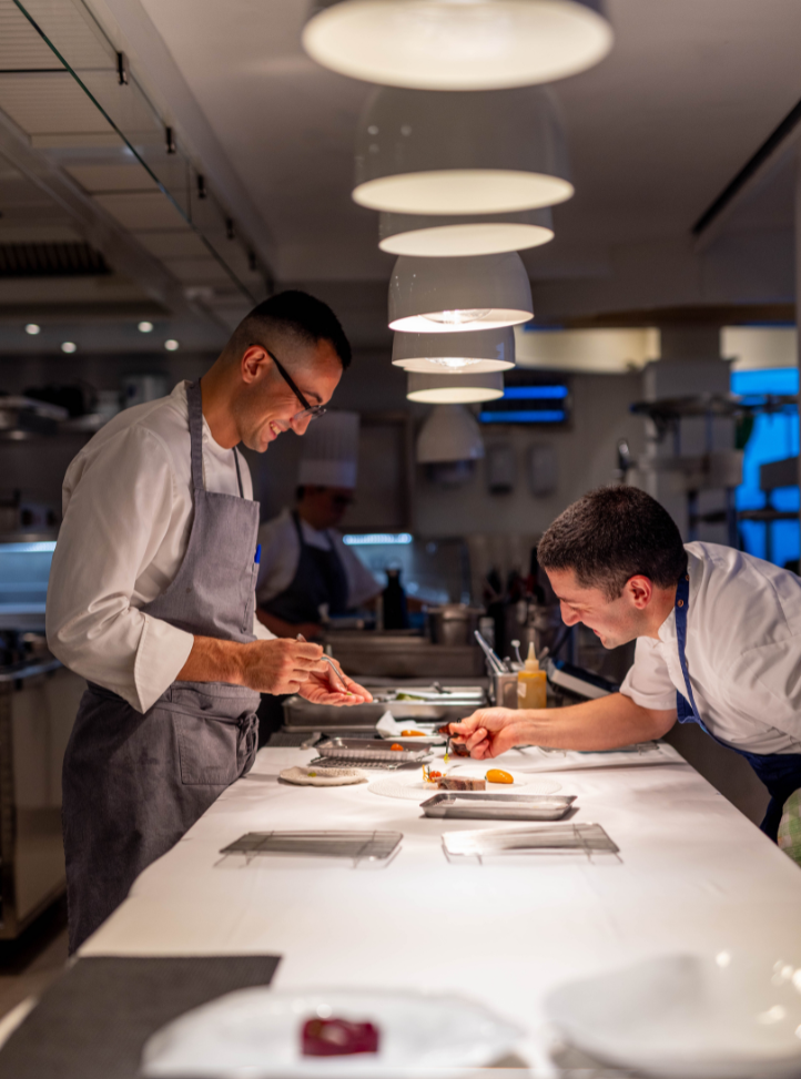 deux chefs cuisinant ensemble dans un restaurant - two chefs cooking together in a restaurant's kitchen