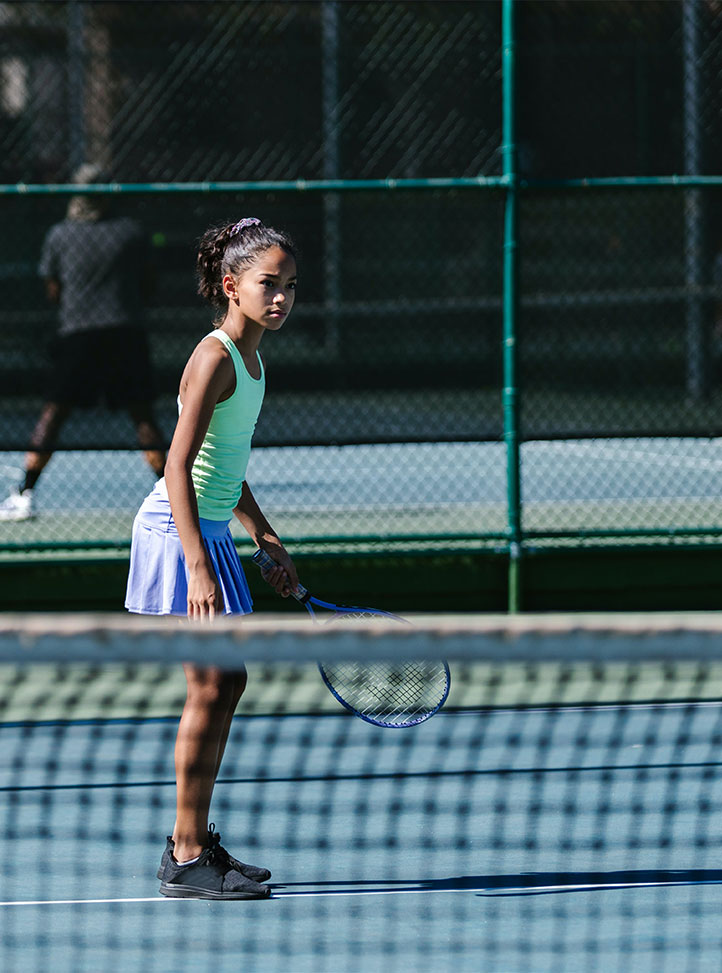 Fillette d'environs dix ans qui joue au tennis. Ten-year-old girl playing tennis.