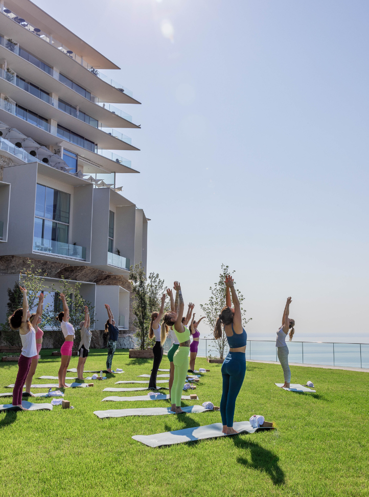 groupes participant à un cours de yoga sur la pelouse face à la mer - group of people during a yoga class on the lawn in front of the sea