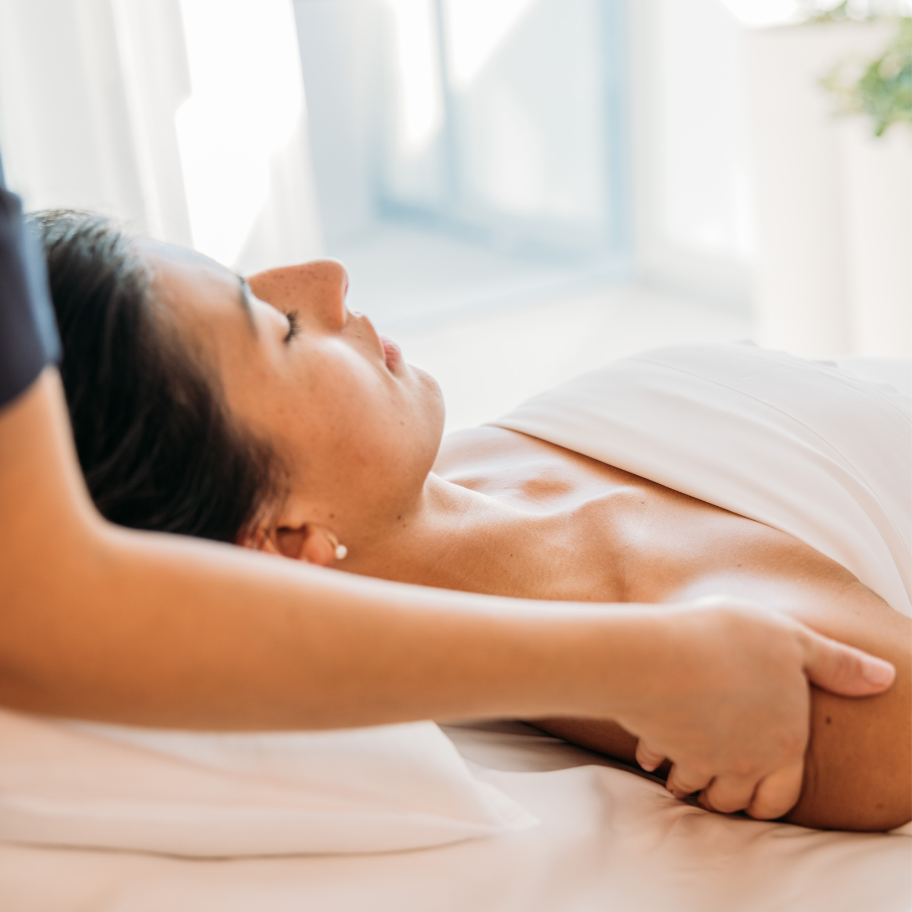 femme se faisant masser sur une table de massage - women receiving a massage on a treatment table