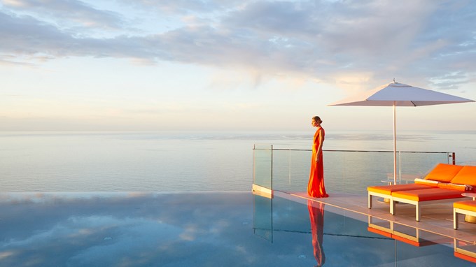 A model standing next to the pool at The Maybourne Riviera