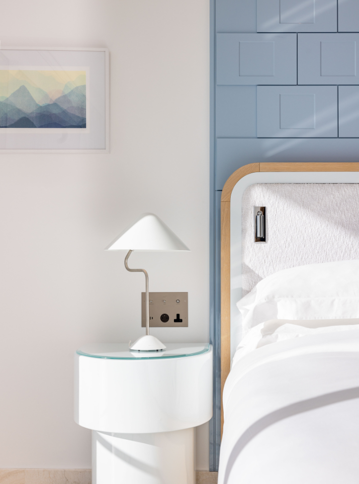 Photo du côté d'un lit avec une table de nuit et une lampe - Image of the side of a bed and a bedside table with a lamp