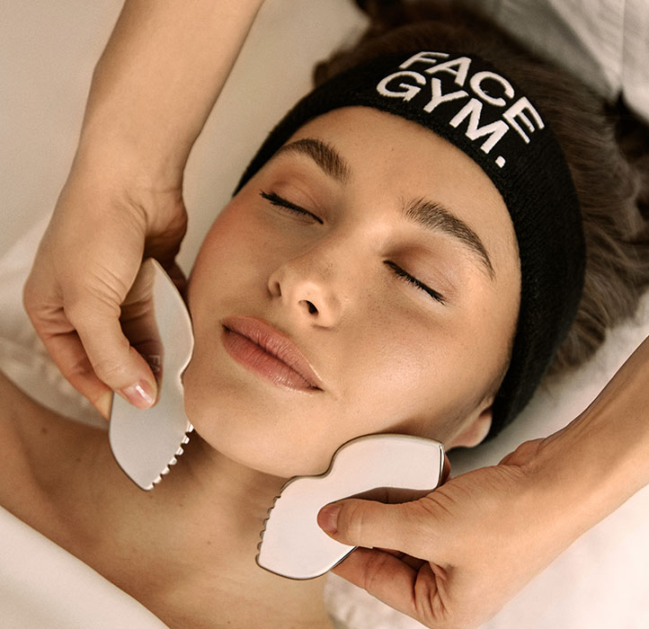 Woman having Facegym Workout treatment wearing a Facegym headband