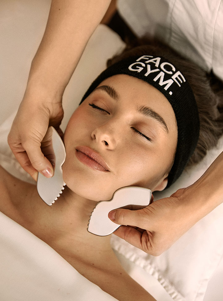 Woman having a Facegym Workout treatment wearing a FaceGym headband.