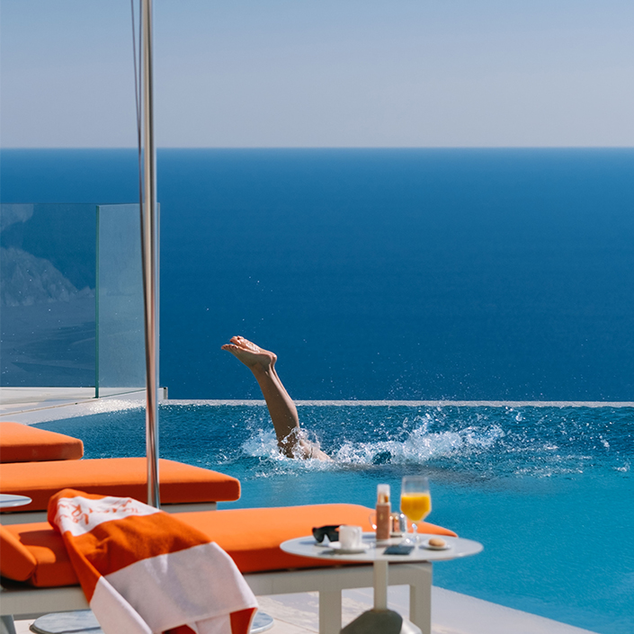 Woman jumping in pool at The Maybourne Riviera